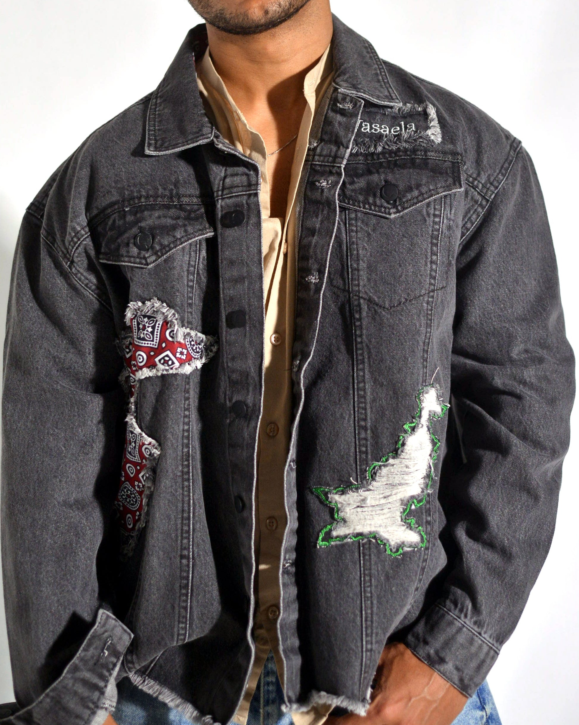 Denim jacket with patches on a plain background